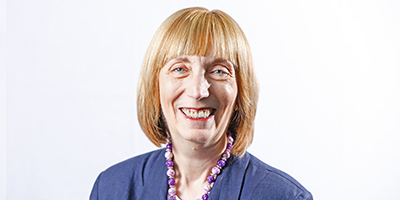 Portrait of a School of Nursing faculty member smiling against a light background.